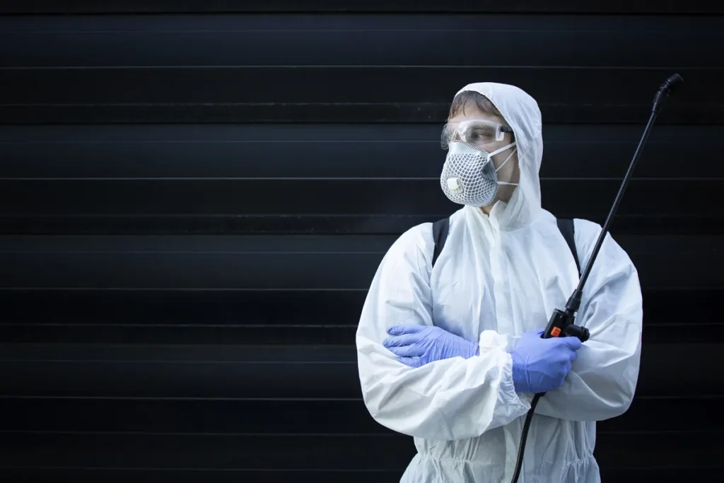 Tecnico della disinfestazione con nebulizzatore durante un intervento di derattizzazione